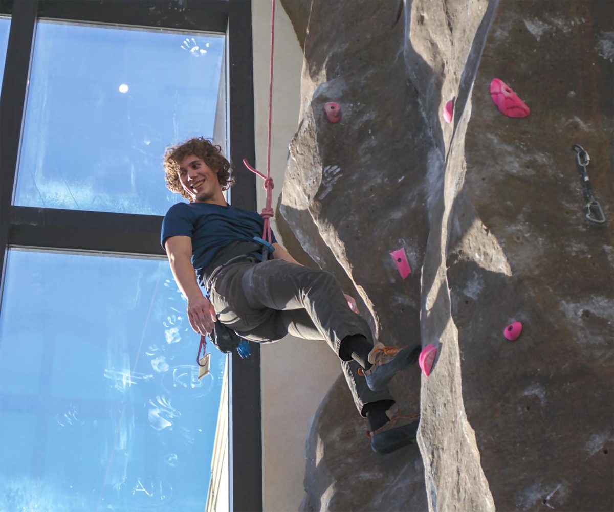 Texas State electrical engineering freshman James Dube takes a break during his climb to look back at his belay, Friday, Feb. 23, 2024, at the Student Recreation Center.