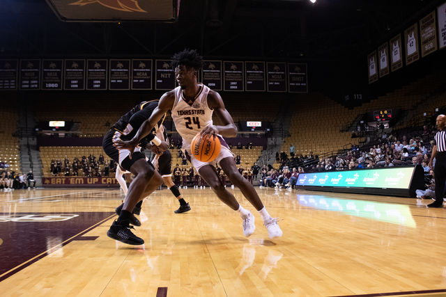 Texas State junior forward Brandon Love (24) dribbles around his defender during the game against Southern Miss, Saturday, Feb 3, 2024, at Strahan Arena.