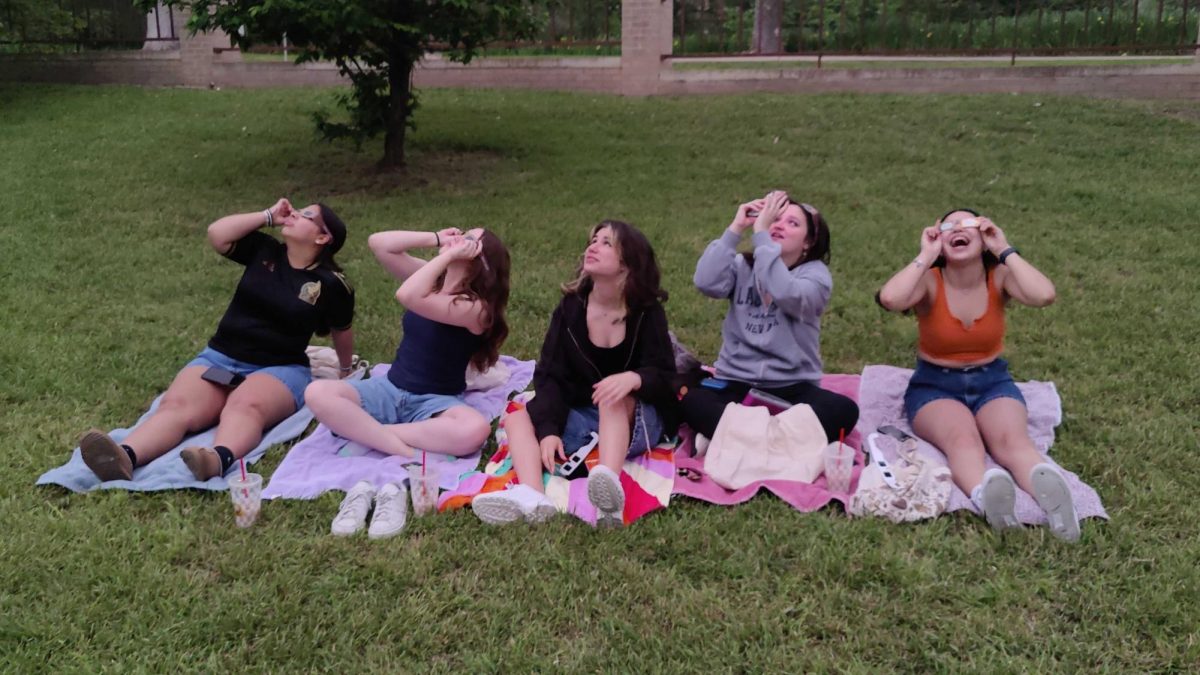 (From left to right) Criminal justice freshman Jazmine Ponce, radiation therapy freshman Ashley Burriz, criminal justice freshman Alyssa Dubuque, music freshman Loretta Wones and criminal justice junior Dalilah Gutierrezz gather to watch the eclipse at Sewell Park, Monday, April 8, 2024, at Texas State.