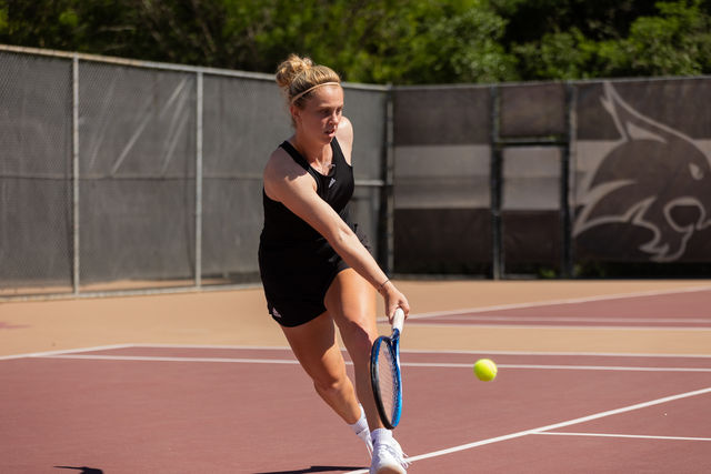 Texas State senior Mae McCutcheon runs to hit the ball during a doubles match against Troy, Friday, April 5, 2024, at Bobcat Tennis Complex.