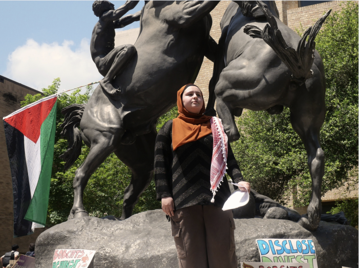 Student Zayna Abdel-Rahim leads off a protest reciting a speech from the stallions statue, Monday, April 29, 2024, on The Quad at Texas State. 