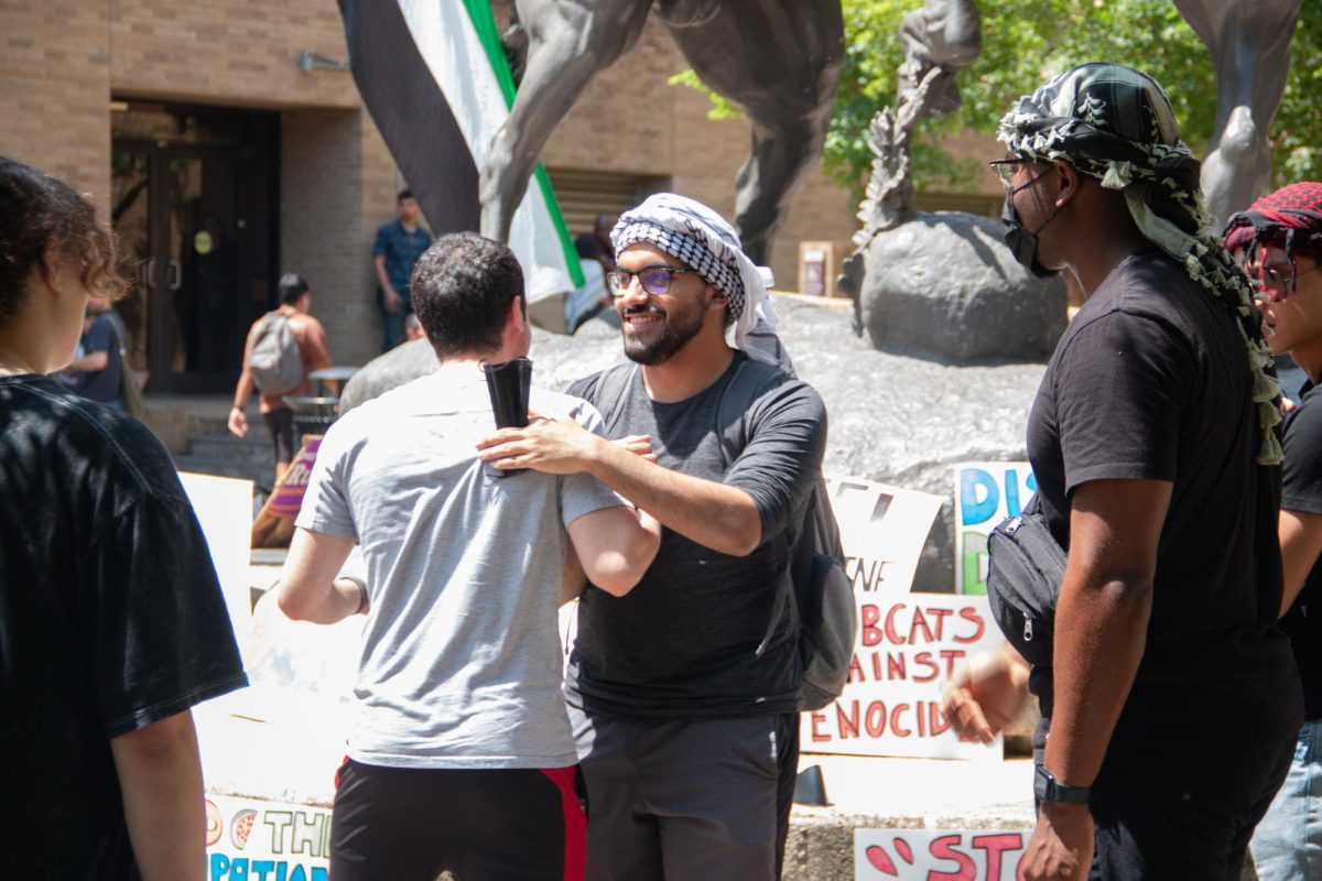 Two supporters of the sit-in for Palestine hug each other before the protest begins at the stallions statue on The Quad on Monday, April 29, 2024. 