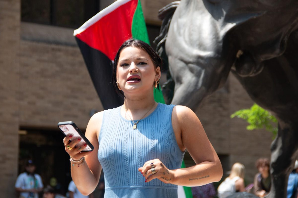 Averyann Guggenheim, president of College Democrats at Texas State University, gives a speech off her phone at the sit-in for Palestine on The Quad on Monday, April 29, 2024. 