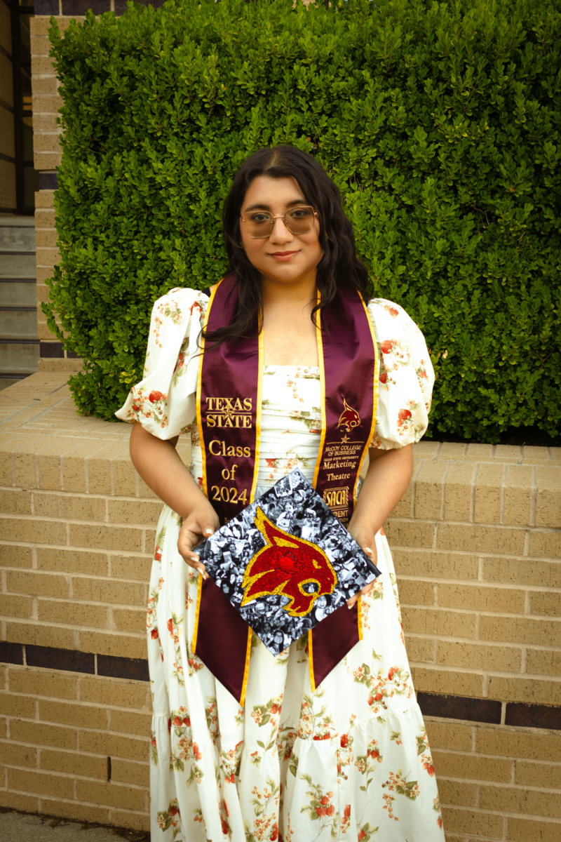 Marketing senior Aili Ortega smiles while holding her cap decorated with her college memories on Saturday, April 20, 2024.