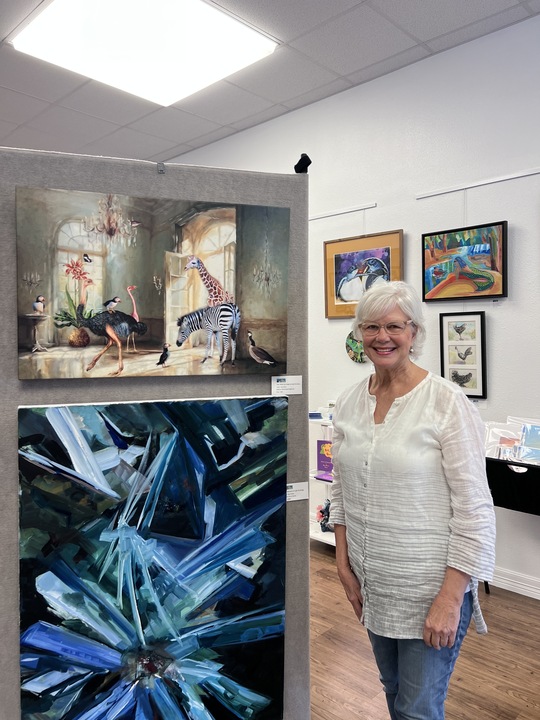 Artist Carol Serur poses with her displayed artwork, When you forget to close the door..., following the San Marcos Art League May Showcase, Thursday, May 30, 2024, at the San Marcos Art Center.