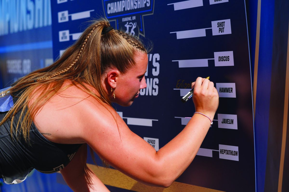 Texas State sophomore thrower Elisabeth Runarsdotir signs her name on the championship board after winning the women’s hammer throw event at the NCAA Outdoor Championships, Thursday, June 6, 2024, at Hayward Field in Eugene, Oregon.  