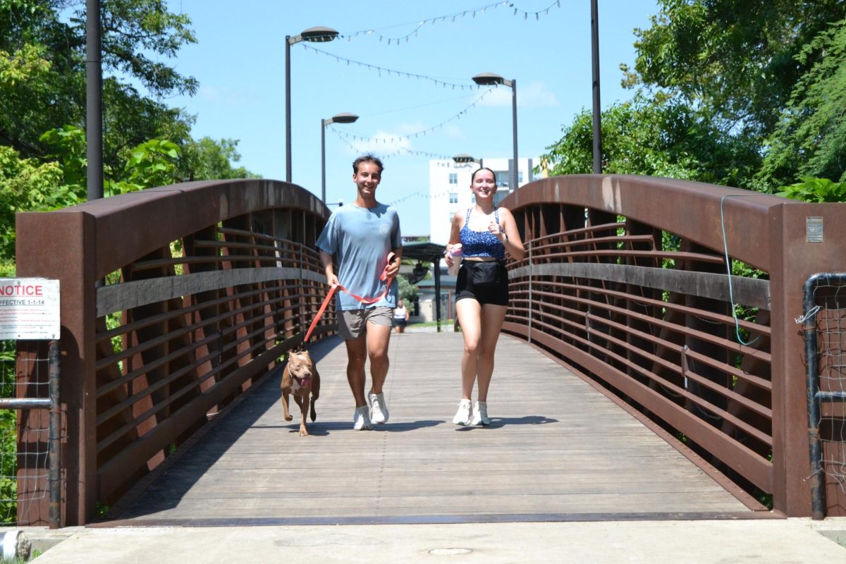 Texas State Alumnus Ben Nudelman, Rachel Fletcher and dog Mila run in Bikini Hill Run Club, Sunday, July 21, 2024, at Sewell Park. Mila is the first dog to run with the run club. 