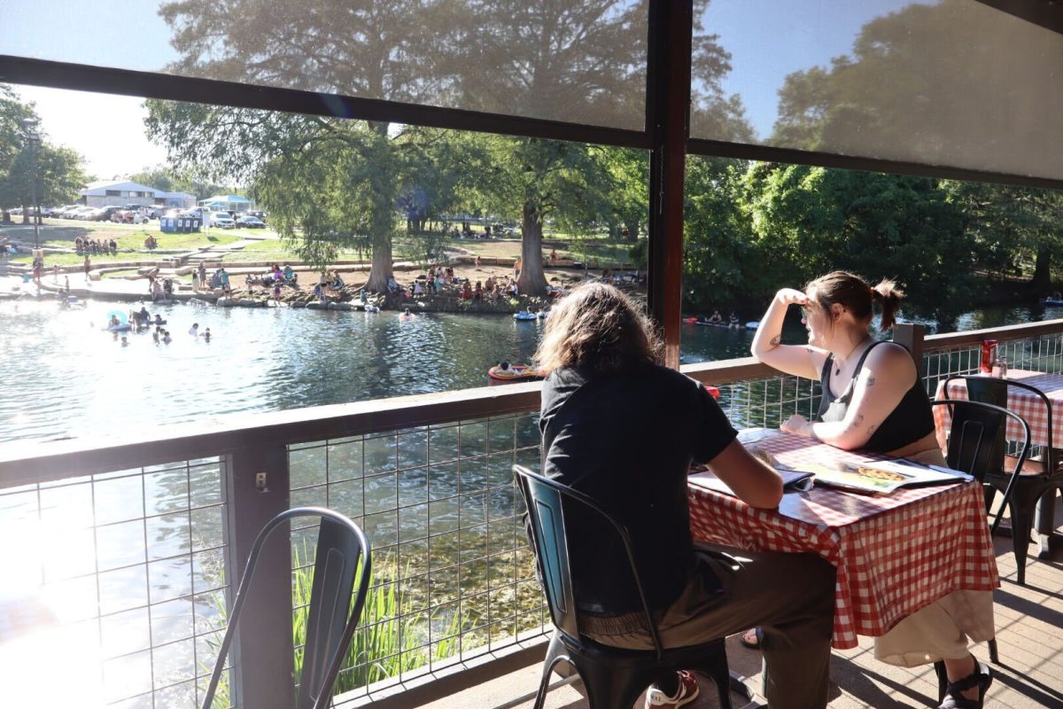 A couple overlooks the scenic view of the river from the back patio area while waiting for their food, Sunday, Sept. 8, 2024, in San Marcos.