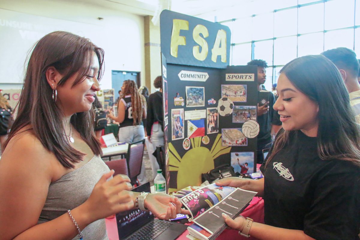 Pre-Nursing sophomore Danah Janine Ceniza (Right) hands out pamphlets of information about the Filipino Student Association to students at the student involvement fair, Thursday, Sept. 5, 2024, in the LBJ Student Center Ballroom.