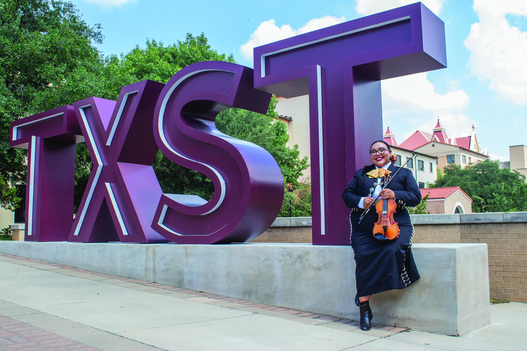 Social work junior Abby Garcia sits in front of the TXST sign on campus, Monday, Sept. 16, 2024, at Bobcat Trail.