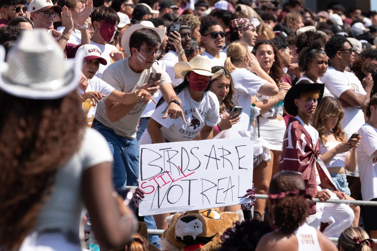 Texas State mascot Boko holds up sign "Birds are still not real" to hype up the student section crowd during the I-35 Showdown versus UTSA, Saturday, Sept. 7, 2024, at UFCU Stadium.