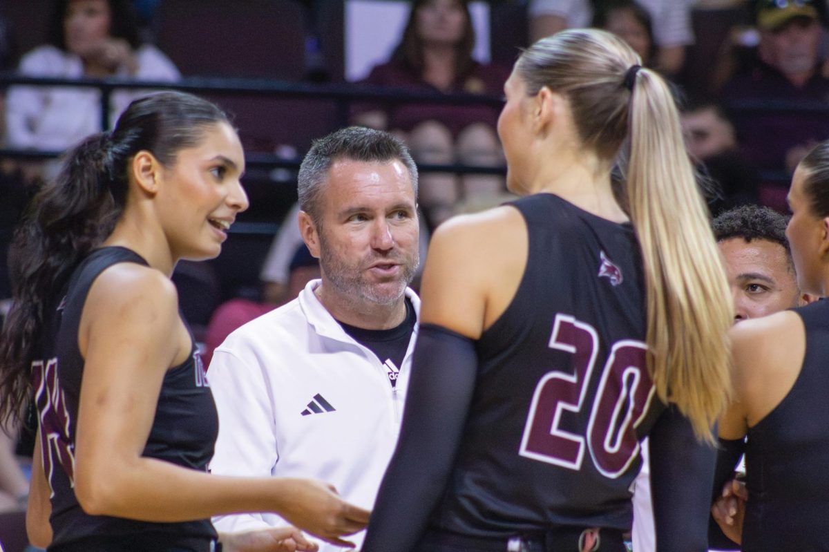 Texas State volleyball Head Coach Sean Huiet coaches junior middle blocker Bailey Hanner (20) and senior setter Ryann Torres (14) through a timeout during the game versus Lamar, Saturday, Aug. 24, 2024, at Strahan Arena. 