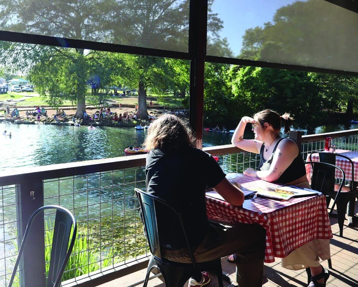 A couple overlooks the scenic river from the back patio area while waiting for their food, Sunday, Sept. 8, 2024 at Ivar's River Pub in San Marcos.