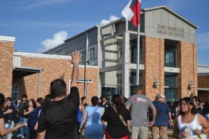 A man waves at students as kids are released, Tuesday, Sept. 24, 2024, from San Marcos High School. Students were released from lockdown starting at 5:30 p.m.