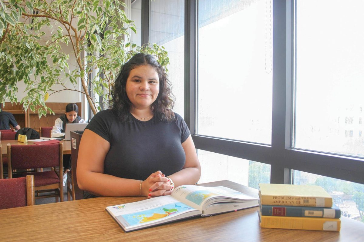 Geographic education doctorate student Diane Nunez poses at a table, Thursday, Oct. 3, 2024, in the geography section of Alkek Library.