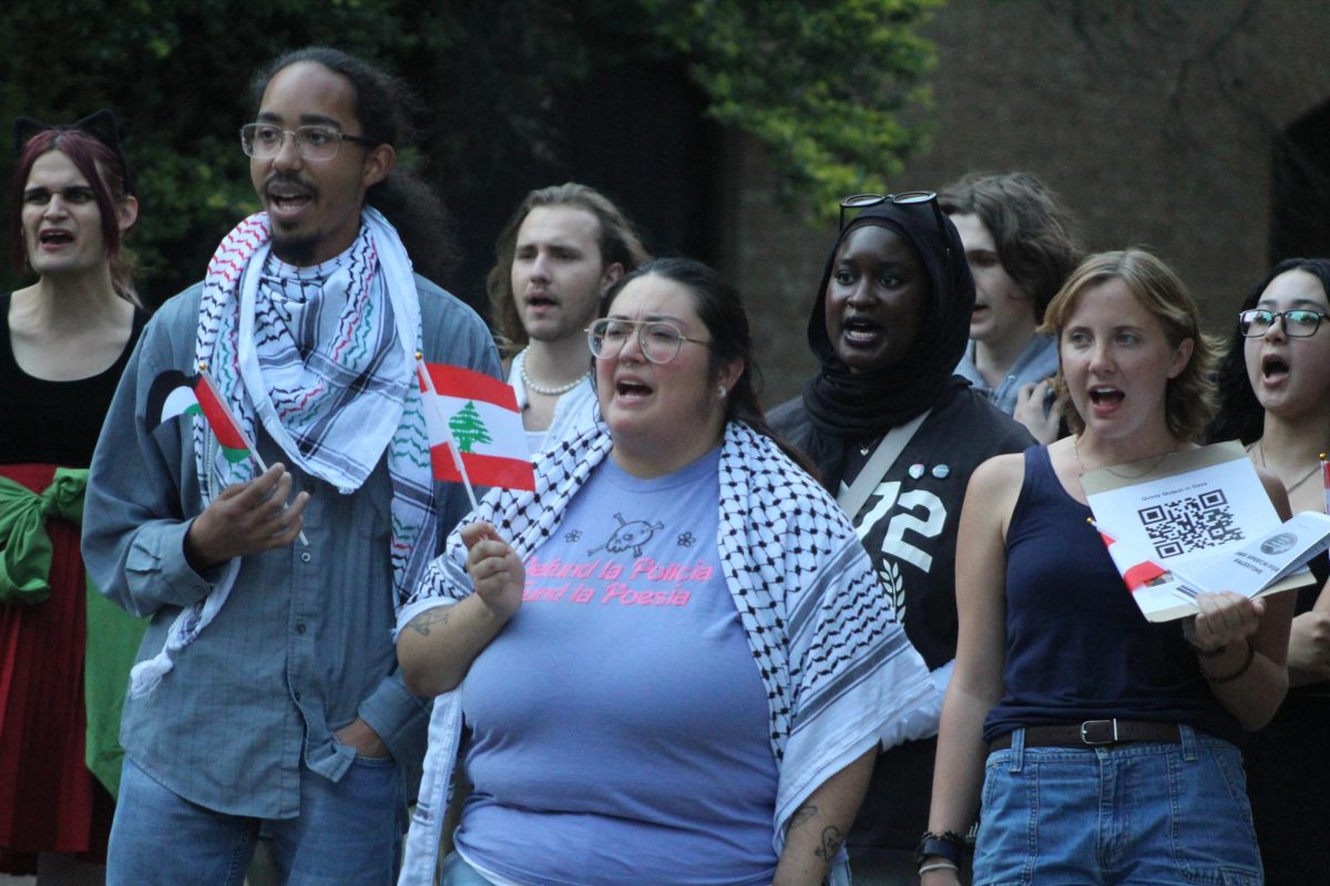 Community members participate in chants while holding Palestine Flags at the Stallions on Tuesday, Oct. 8, 2024.