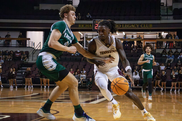 Texas State graduate student forward Tyrel Morgan (1) dribbles around his Eastern Michigan defender, Monday, Nov. 11, 2024, at Strahan Arena.