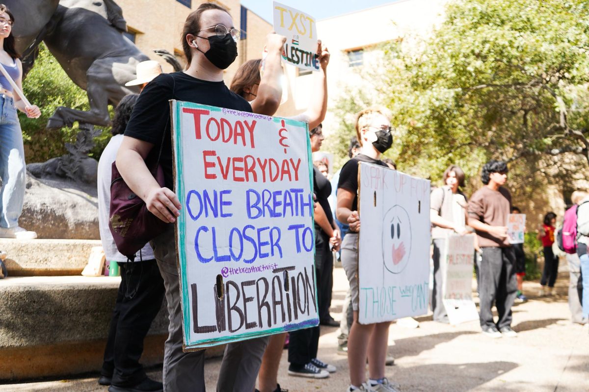 Students hold signs for a free Palestine, Wednesday, Nov. 13, 2024, at the Stallions.