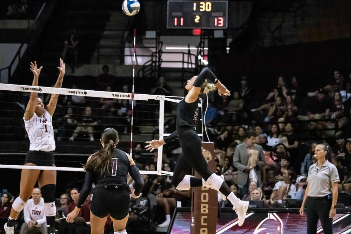 Texas State redshirt sophomore outside hitter Samantha Wunsch (8) spikes the ball over the net towards Troy. Friday, Oct. 4, 2024, at Strahan Arena.