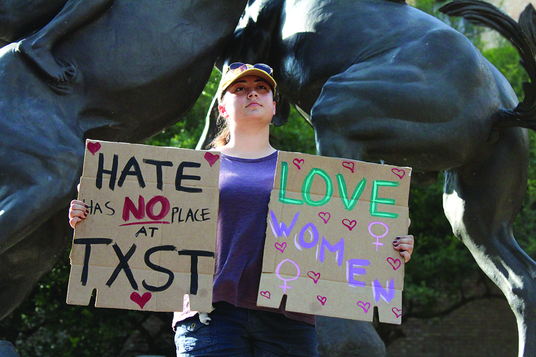 English freshman Celia Strang holds positive signs, Thursday, Nov. 7, 2024, at the Stallions statue.