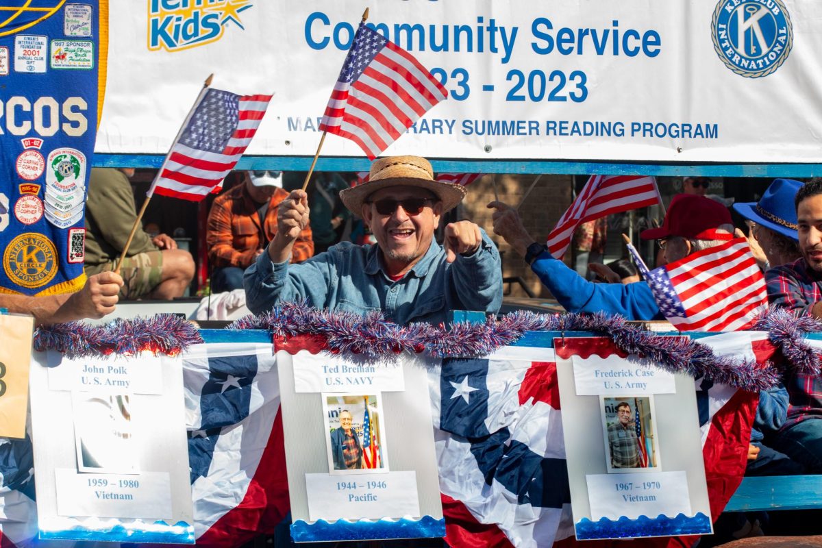 A veteran on the San Marcos Kiwanis Club’s float waves and points to crowd members during the San 
Marcos Veterans Day Parade, Saturday, Nov. 9, 2024, through Downtown San Marcos.