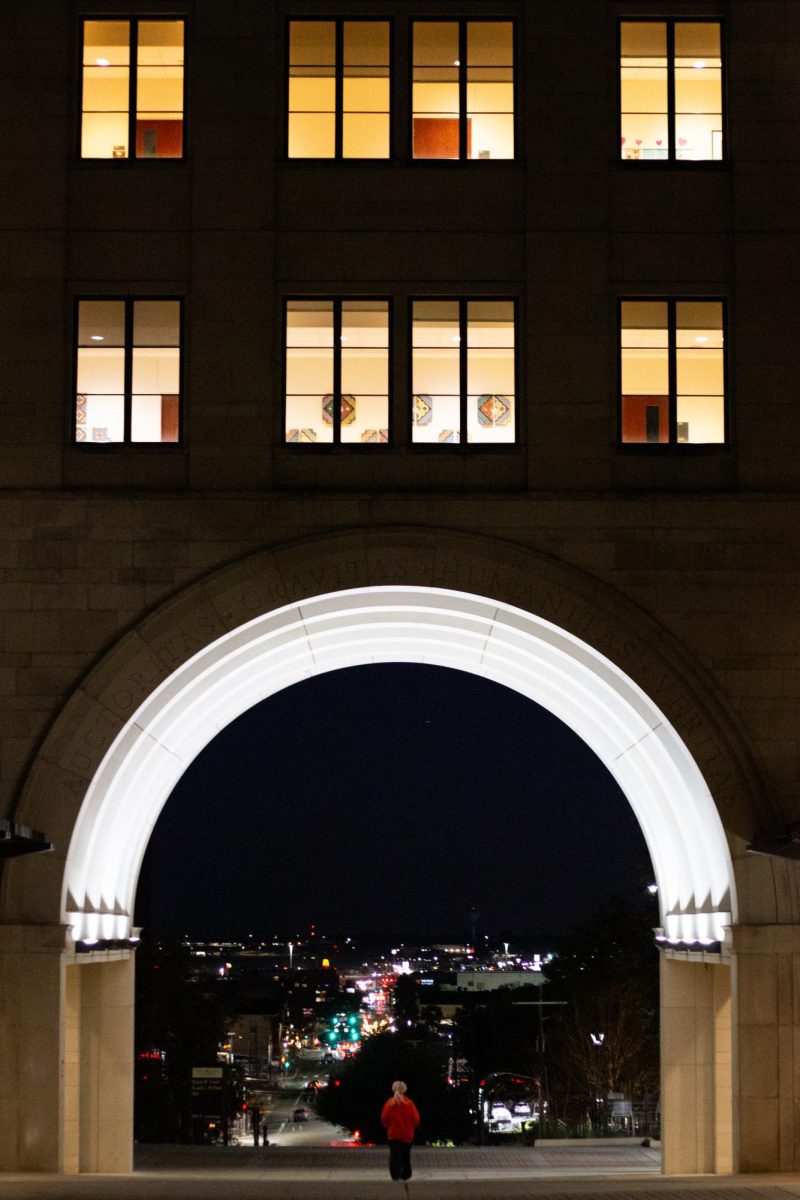 A student passes through the glowing Trauth-Huffman Hall arch, Friday, Jan. 24, 2025 at Texas State. 