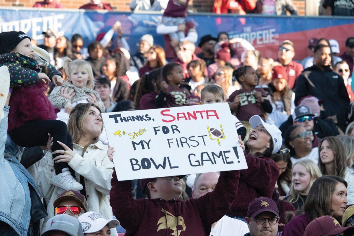 A young Texas State fan holds a sign thanking Santa for tickets to his first bowl game, Friday, Jan. 3, 2025, at Gerald J. Ford Stadium.