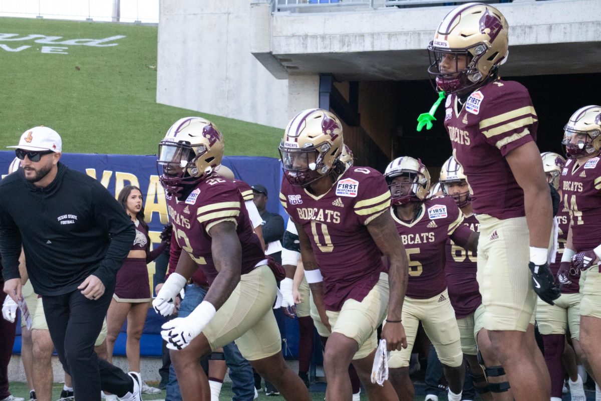 Texas State junior defensive end Kalil Alexander (22) and head coach G.J Kinne lead the football team onto the field to face North Texas at the SERVPRO First Responder Bowl, Friday, Jan. 3, 2025, at Gerald J. Ford Stadium.
