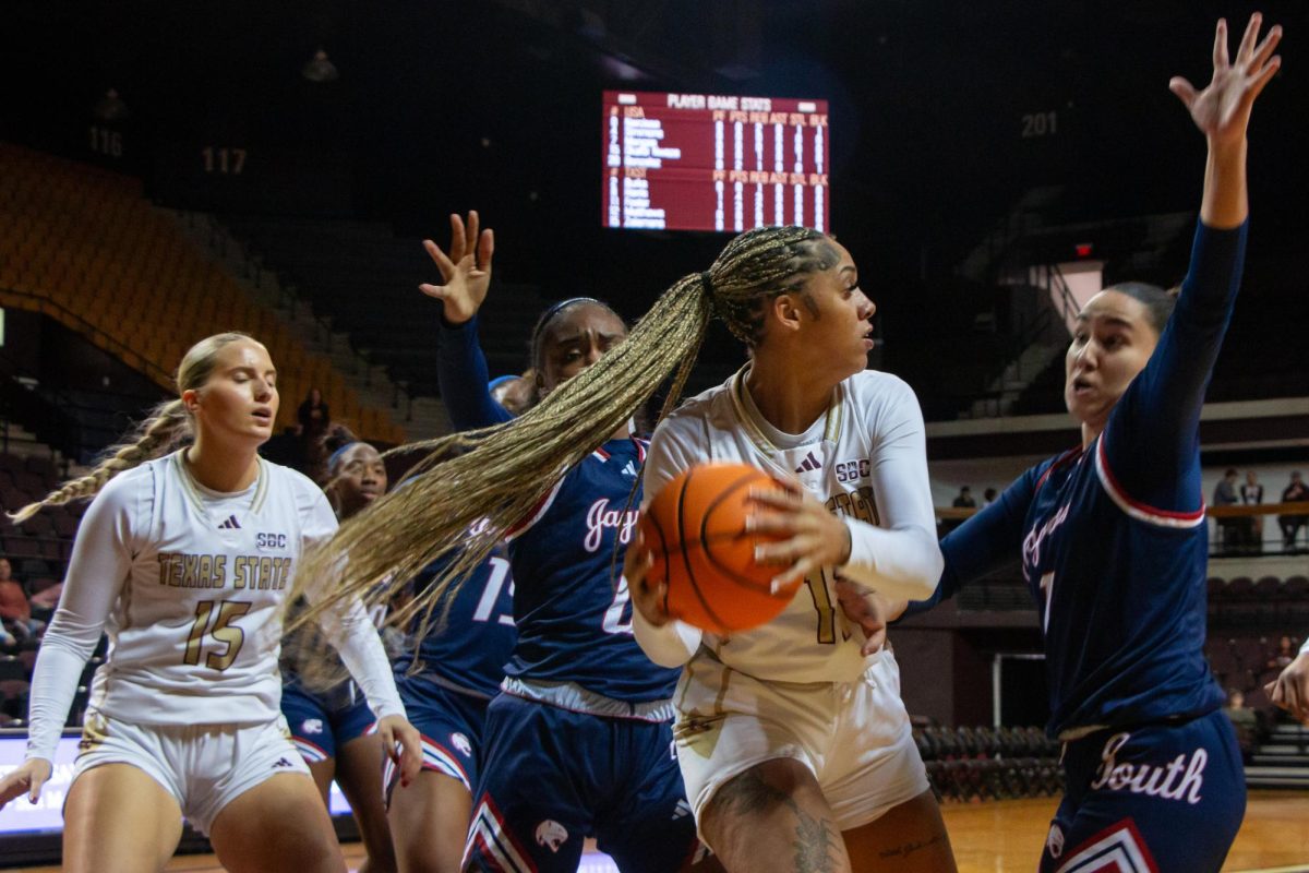 Texas State senior forward Jaylin Foster (11) looks to dodge University of South Alabama players during the game, Saturday, Jan. 11, 2025, at Strahan Arena.