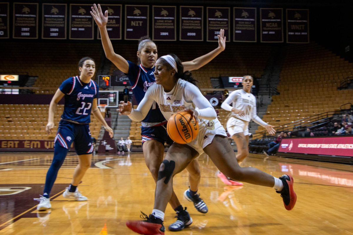 Texas State sophomore guard Ja'Mia Harris (8) dodges a University of South Alabama player towards the hoop during the game, Saturday, Jan. 11, 2025, at Strahan Arena.