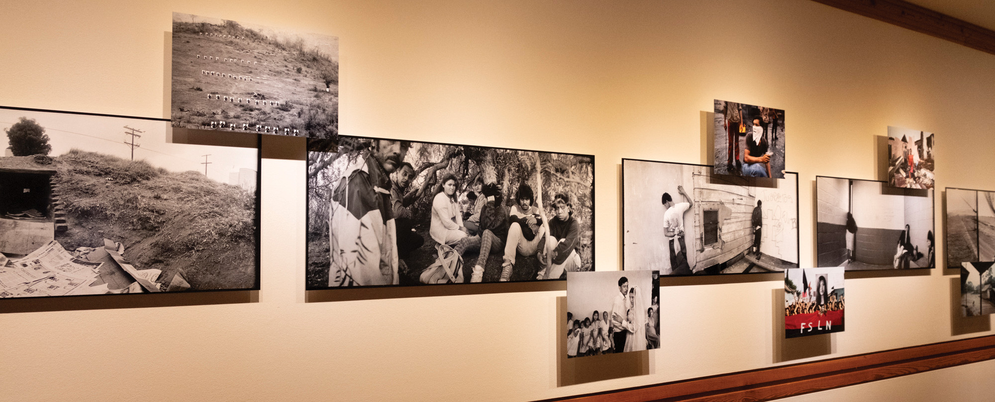 Photos from Susan Meiselas’ “Crossings” exhibit hang on a wall, Tuesday, Oct. 8, 2024, at the Wittliff Collections.