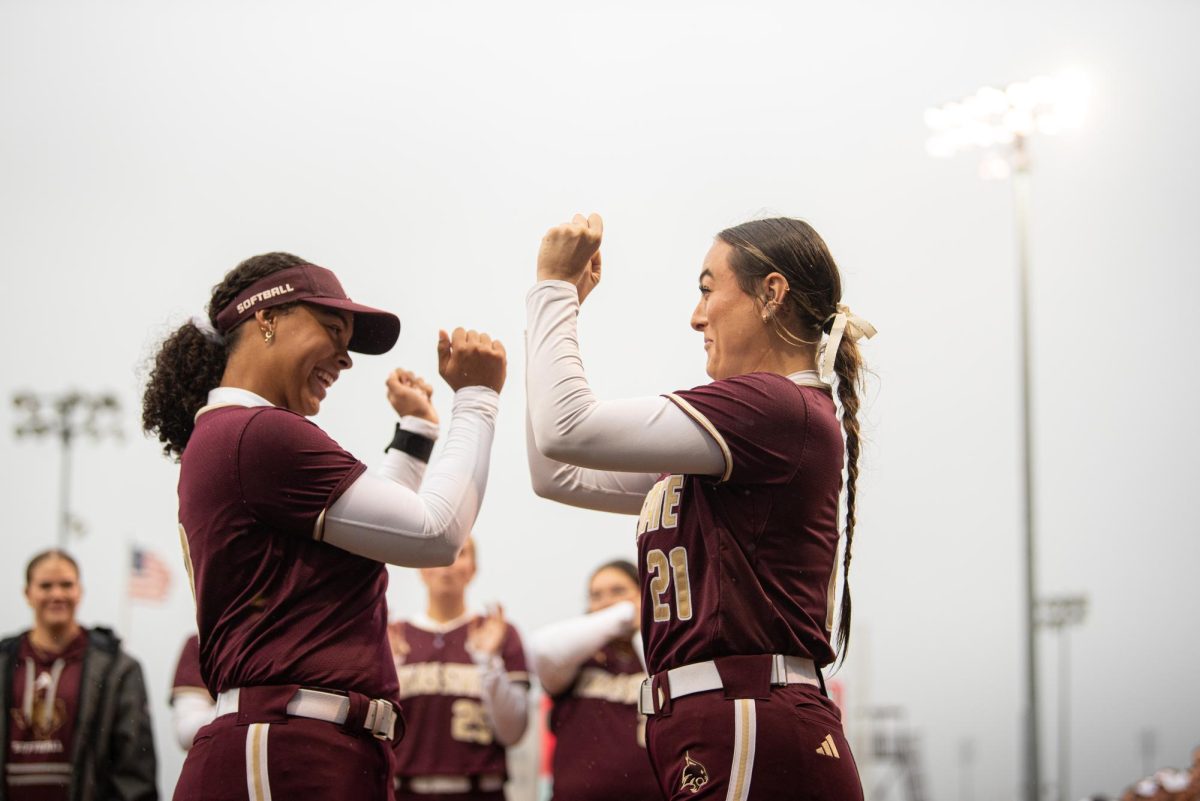 Texas State junior #13 Keely Williams and Applied Arts & Sciences Senior #21 Presley Glende greet each other on the field at the Texas State Softball game against Sam Houston State University on February. 18, 2025.