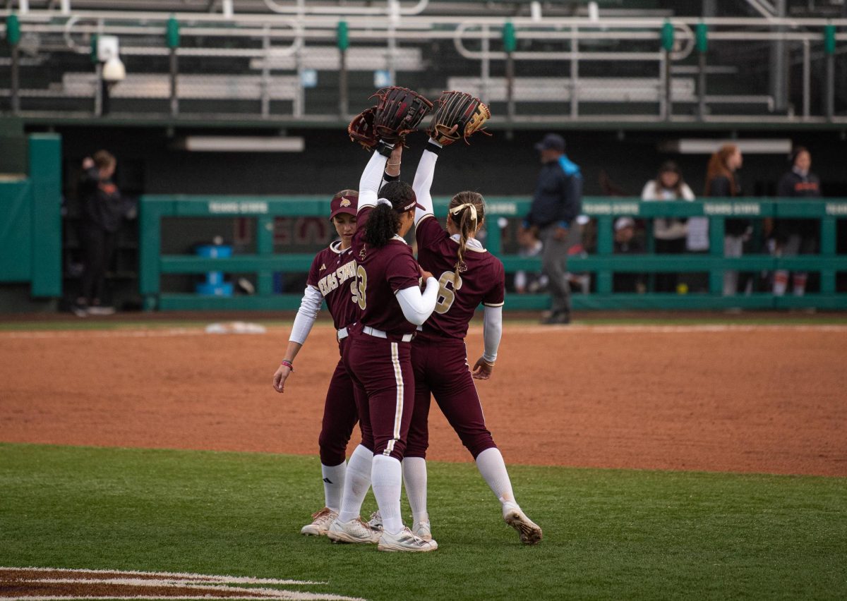 Texas State Junior #13 Keely Williams, senior #6 Ciara Trahan and Junior #9 Sydney Harvey hype each other up during the first inning of the Texas State Softball game against Sam Houston State University on February. 18, 2025.