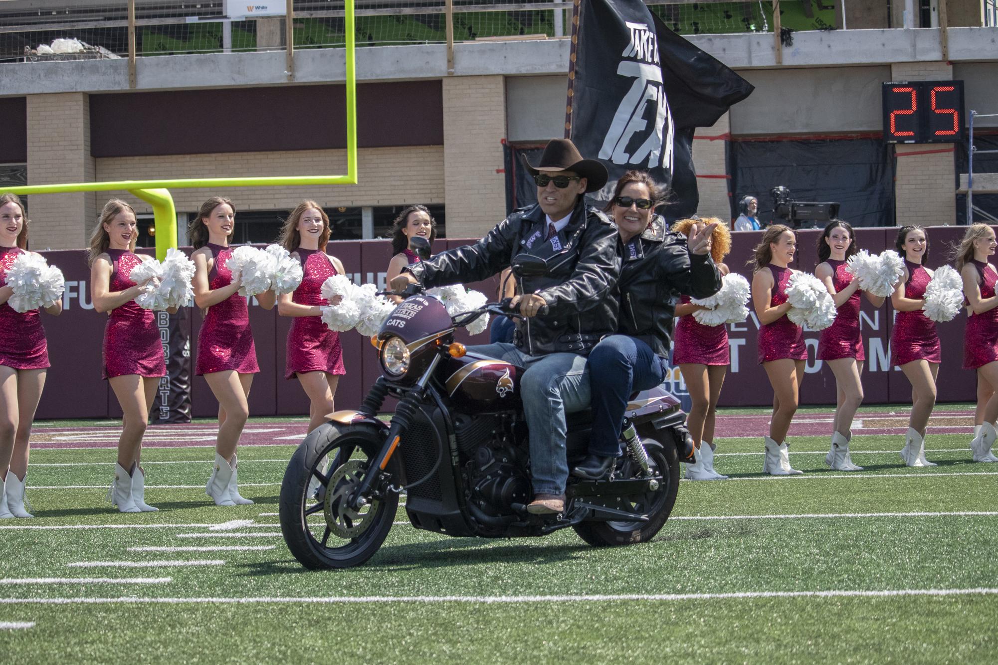 Texas State University President Kelly Damphousse and his wife Beth Damphousse kick off the Texas State football game against UTSA by riding a motorcycle onto the field, Saturday, Sept. 7, 2024 at UFCU Stadium. Bobcats beat the Roadrunners 49-10.