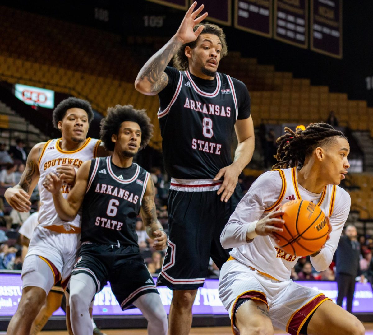 Sophomore guard Kaden Gumbs (11) twists around Arkansas State University players during the men's basketball game, Saturday, Feb. 1, 2025, at Strahan Arena.