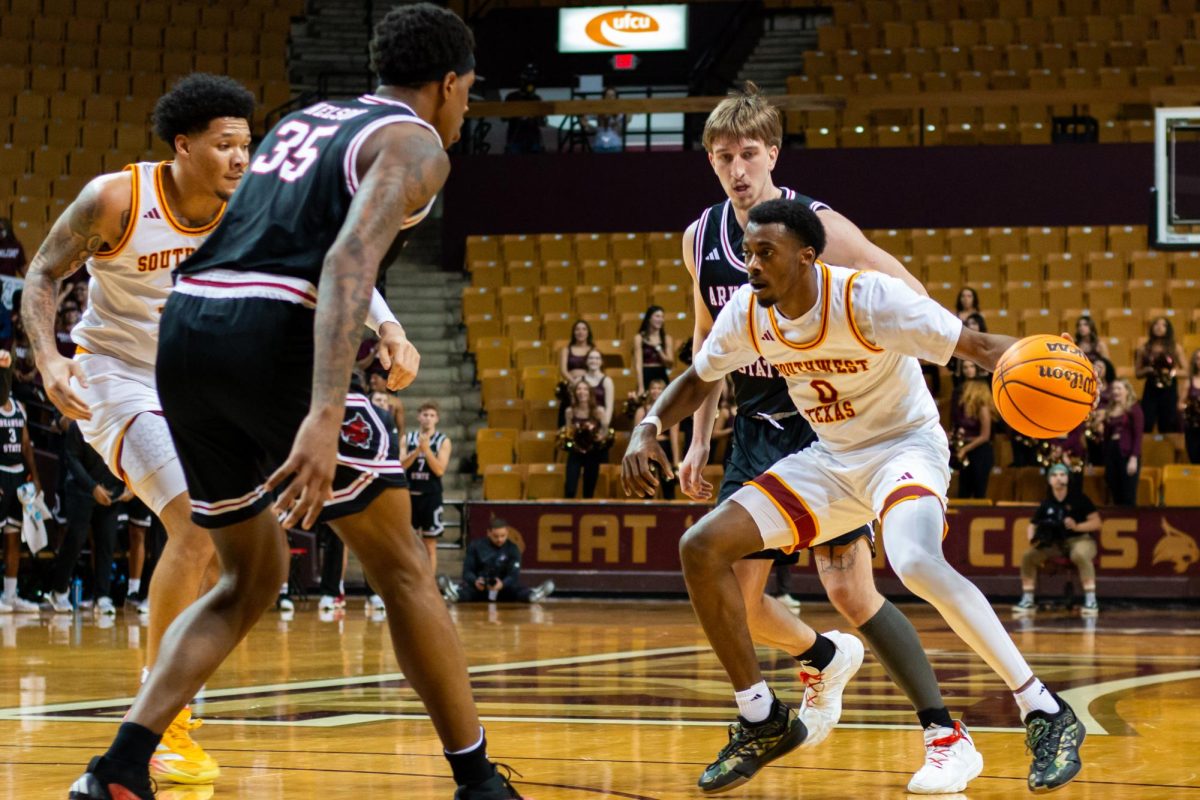 Texas State graduate guard Dylan Dawson (0) looks for an open teammate to pass the ball to during the men's basketball game against Arkansas State University, Saturday, Feb. 1, 2025, at Strahan Arena.