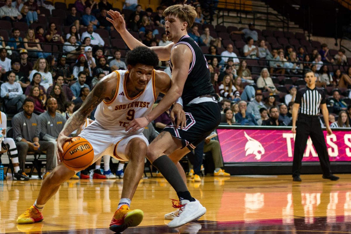 Redshirt senior Tylan Pope (9) pushes past an Arkansas State University player to head towards the basket during the men's basketball game, Saturday, Feb. 1, 2025, at Strahan Arena.