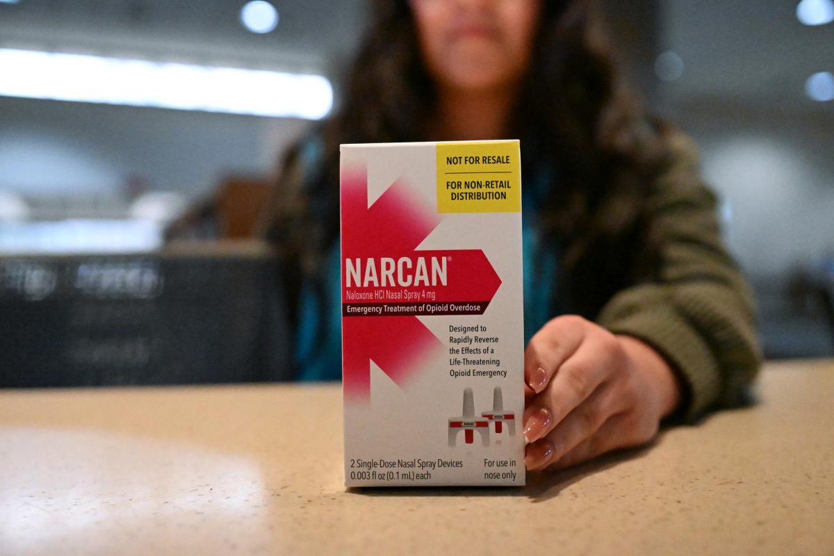 Freshman Viviana Nava displays a box of Narcan at the Alkek ‘Ask Us’ counter, Wednesday, Feb. 12. Narcan is also available at the Student Health Center and the Student Recreation Center.