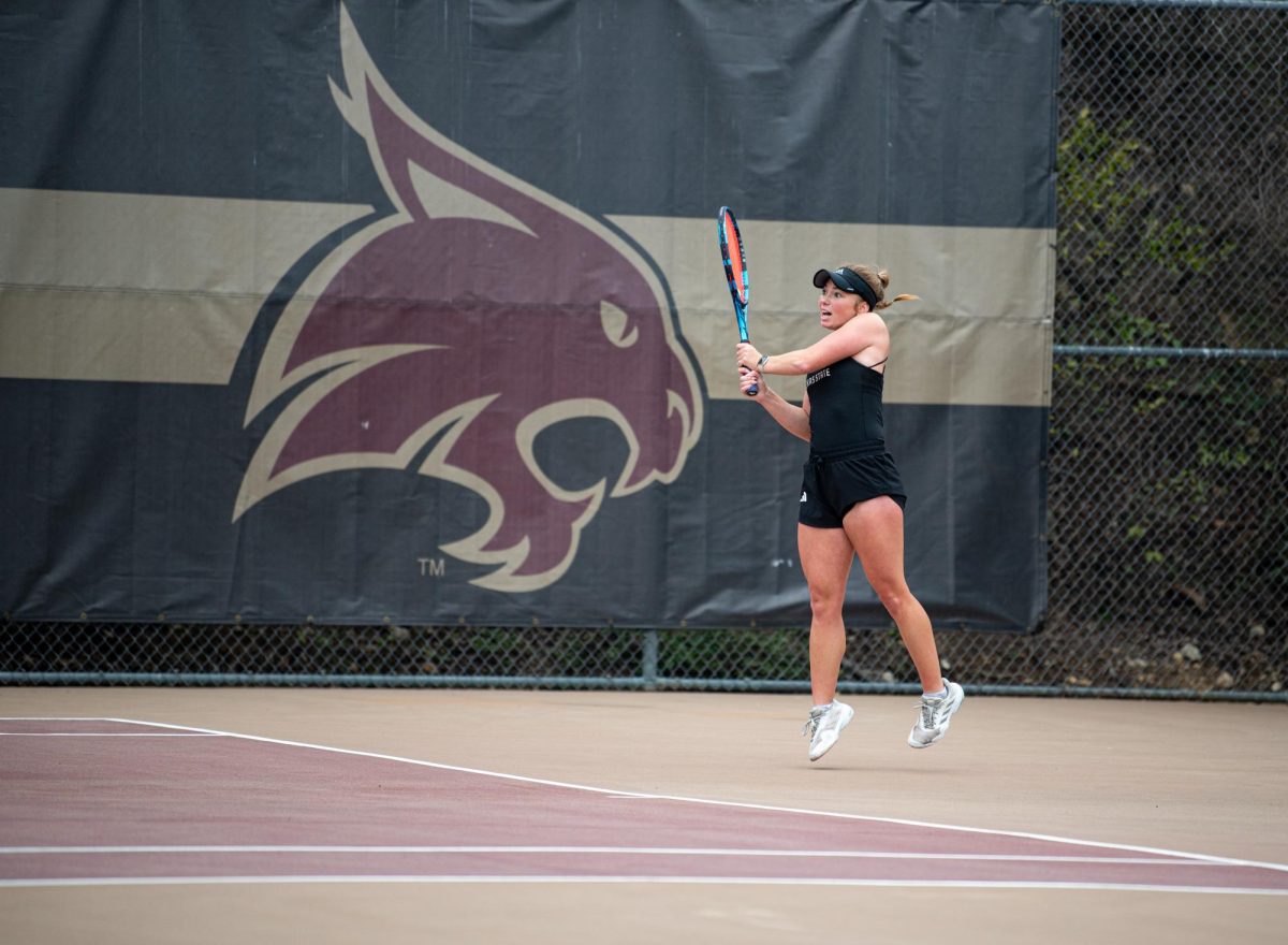 Texas State junior Ireland Simme jumps off the ground as she send the ball over the net to her Tarleton State opponent at the match on Feb. 14, 2025.