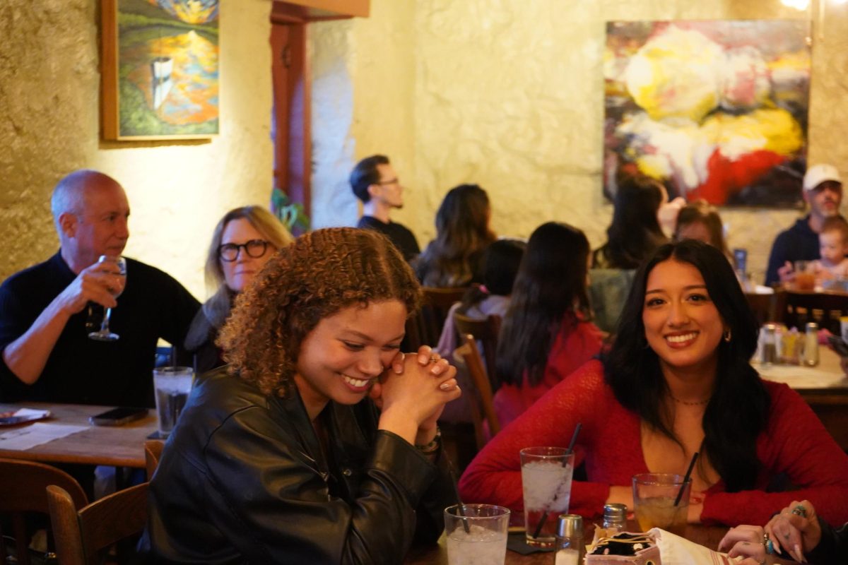 Customers Alliyah Harris (Left) and Danielle Machado (Right) have a conversation while waiting for their food, Sunday, Feb. 16, 2025, The Root Cellar. The Root Cellar stopped serving lunch and dinner on Feb. 16 to make a more efficient workflow.