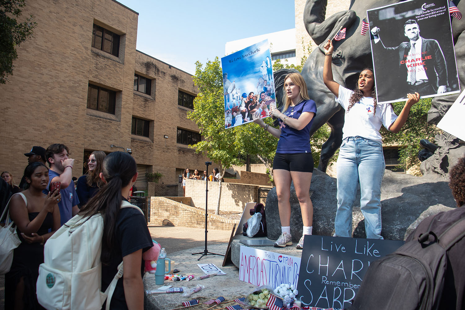The presidents of Texas State's chapter of Turning Point USA, political science sophomore Leona Salinas (left) and exercise and ports science senior Sara Hassel (right) holds signs honoring conservative media personality Charlie kirk who was killed on Sept. 10, Monday, Sept. 15, 2025 on the Quad.