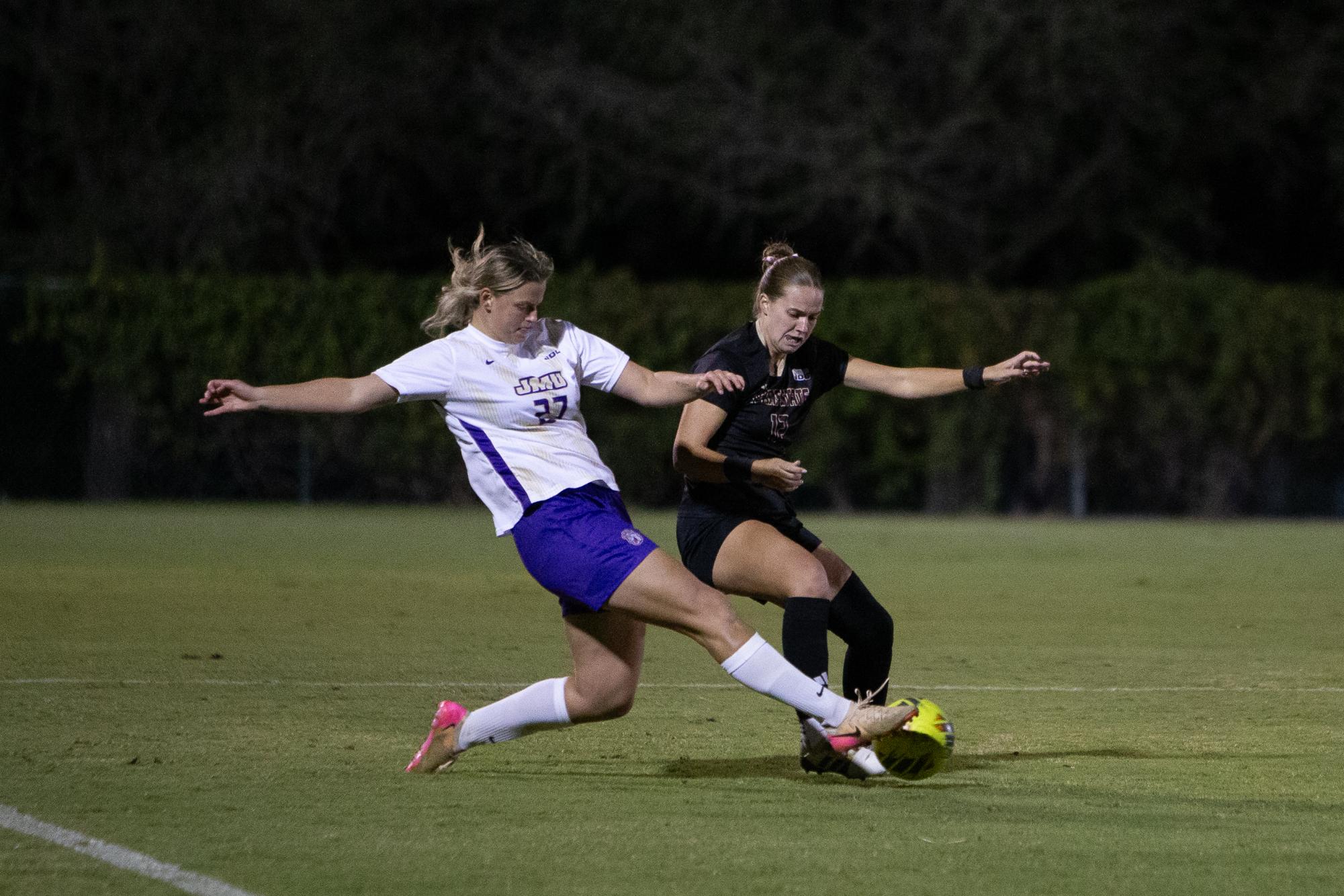 Texas State graduate defender Kennley Bradley (12) narrowly avoiding a tackle from a James Madison defender, Wednesday, Oct. 29, 2025, at Bobcat Soccer Complex. The Bobcats lost 4-2 against the Dukes. 