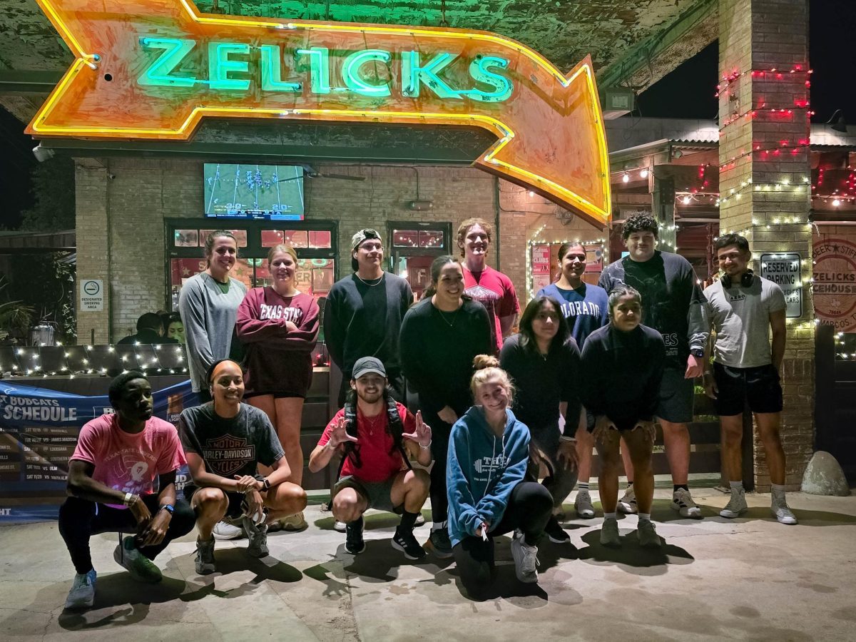 The THRC Run Club begin their weekly meetings with a group photo, Tuesday, Nov. 11, 2025, at Zelicks Icehouse. The running trail takes the club through 2 miles of Downtown San Marcos neighborhoods.