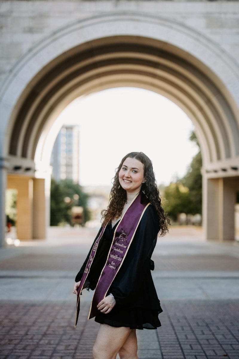 Journalism senior Cara Cervenka poses for her graduate photos, Saturday, Nov. 15, 2025, near Trauth-Huffman Hall at Texas State. Photo courtesy of Claudia Varga.
