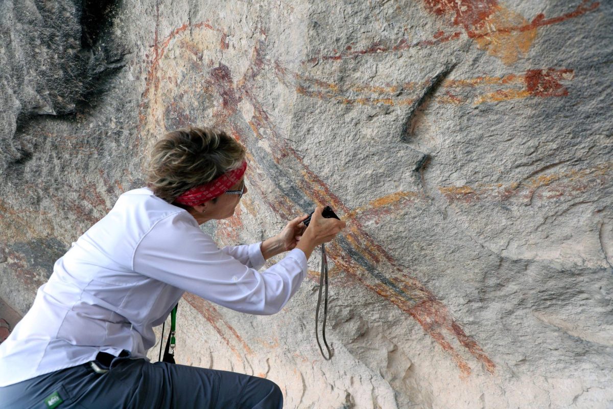 Shumla Endowed Research Professor in the Department of Anthropology Carolyn Boyd analyzes the rock art murals, 2025, along the Pecos River. Photo courtesy of Shumla Archaeological Research and Education Center.