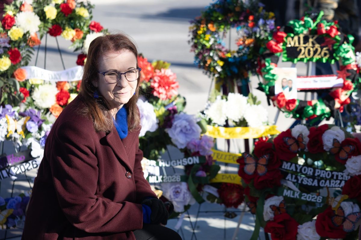 San Marcos Mayor Jane Hughson poses for a photo next to her ceremonial wreath on Monday, Jan. 19, 2026, at the MLK Crossroads Memorial.