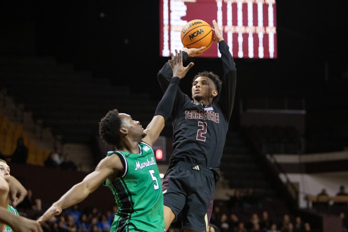 Texas State sophomore guard Franck Emmou (2) takes a shot over a marshall defender Wednesday, Jan 28, 2026 at Strahan Arena. The Bobcats won 72-68.