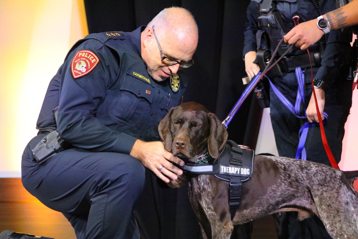 Texas State Chief of Police Matthew Carmichael badges Pawfficer Mando, Wednesday, Jan. 28, 2026, at the LBJ Student Center Ballroom.
