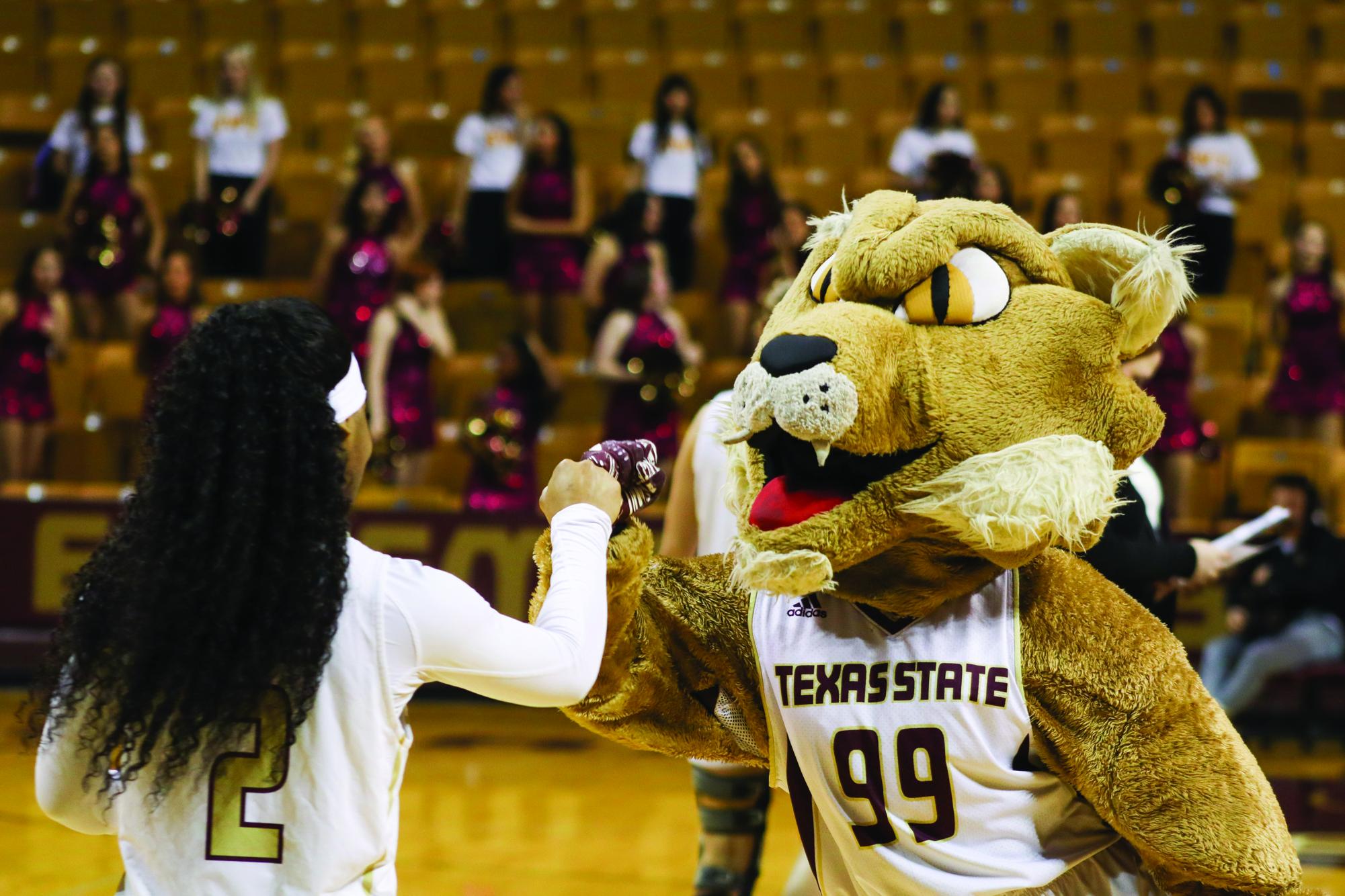 Boko the Bobcat fist bumps Texas State sophomore guard KP Parr (2) after the game against South Alabama, Saturday, Feb. 21, 2026, at Strahan Arena. The Bobcats lost 64-59.