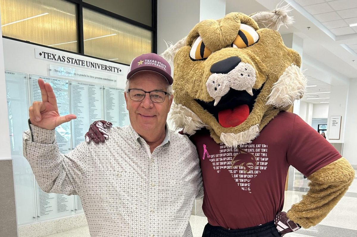 Texas State almunus, donor and superfan Tom Madden poses with Boko with his “State’s Up” hand sign at Strahan Arena. 